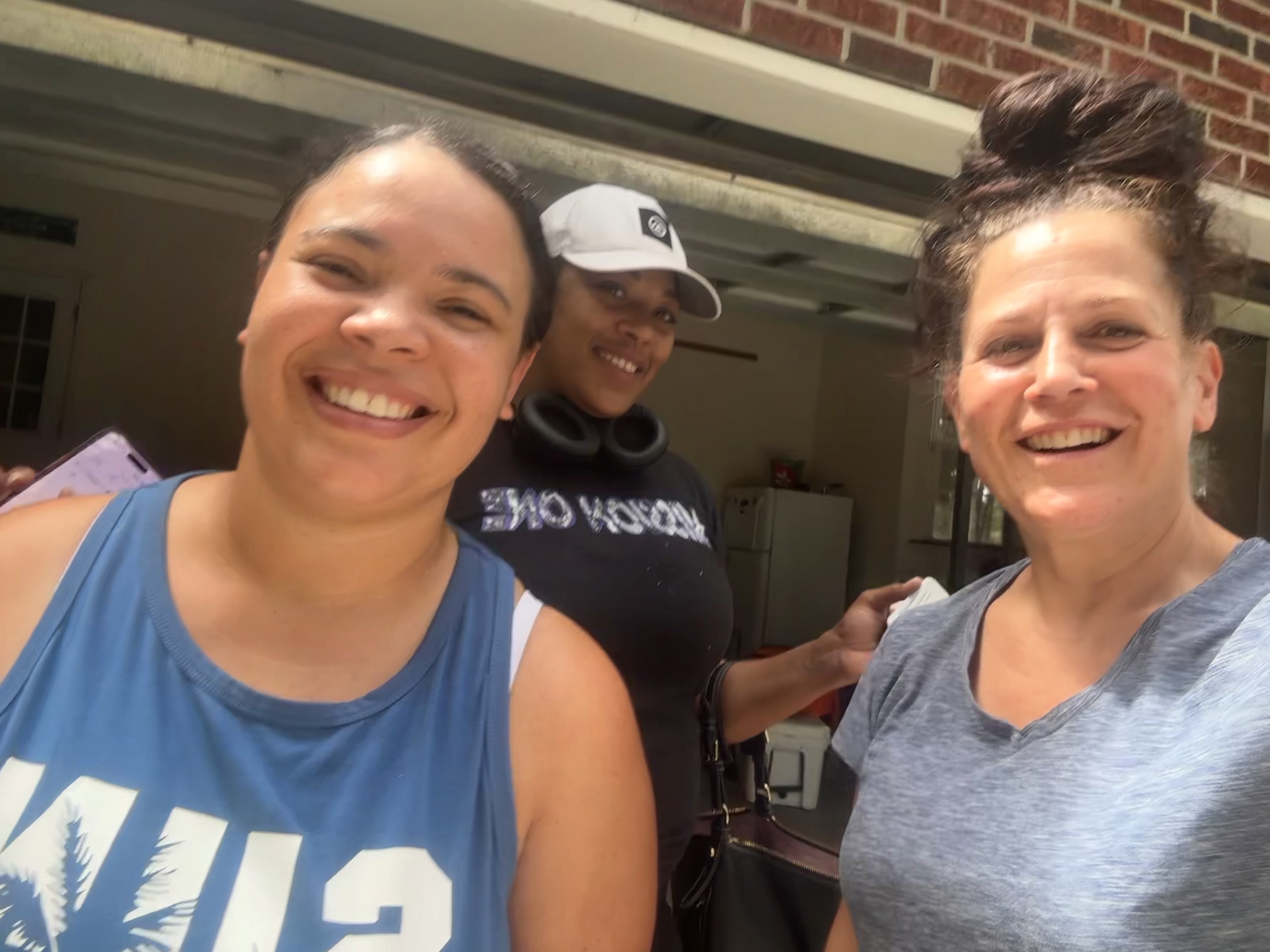 Three smiling members of the Fresh Start Home Cleaning team standing together outside a home.